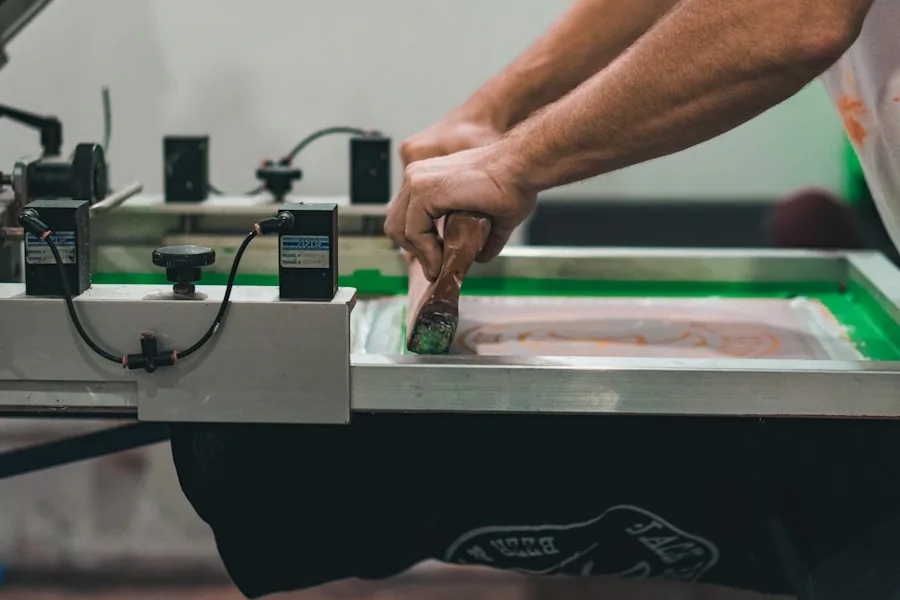 Screen printer applying ink to a graphic T-shirt at a print station